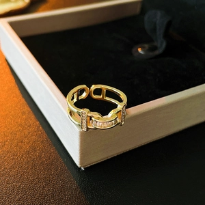 Macro shot of gold plated chain ring with rectangular zircons on pink jewelry box