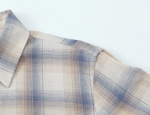 Dettaglio ravvicinato del colletto della camicia a quadri con cuciture e tessuto di cotone