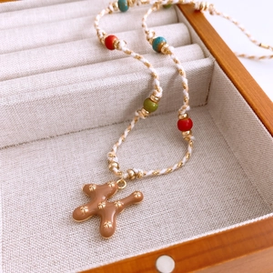 Detail of woven beaded necklace with brown star pendant in beige jewelry box
