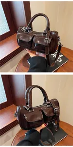 Detail of dark brown glossy saddle bag with double front pockets and silver hardware
