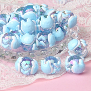 Macro detail of blue glass cat beads for DIY jewelry making on soft lace fabric