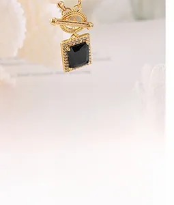 Macro shot of gold OT buckle necklace featuring a square black gemstone with crystal pavé