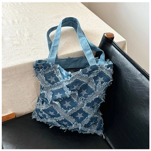 Detail of vintage denim tote bag with frayed star pattern and checkered stitching