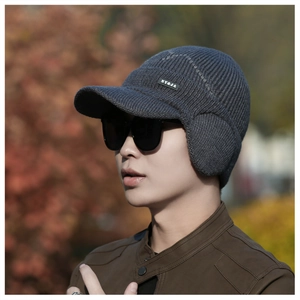 Close-up of men's gray winter knit hat featuring ear protection and a side logo label
