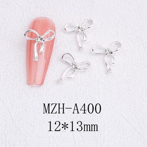 Macro view of silver hollow bowknot nail alloy accessory with a sparkling center rhinestone