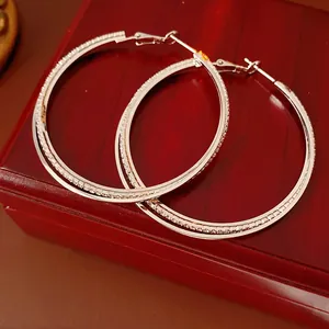Silver double-layered intertwined hoop earrings with sparkling crystal accents
