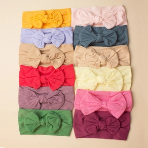 Set of 12 soft nylon baby headbands with large bows in various vibrant colors