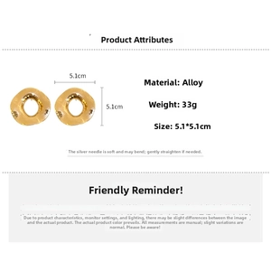 Vue macro de grandes boucles d'oreilles dorées martelées avec détails de taille et poids