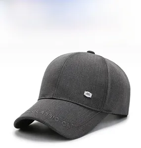 Close-up of metal brand plate and classic embroidery on dark grey baseball cap fabric