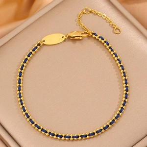 Titanium steel bracelet with golden beads and blue woven cord featuring a lobster clasp