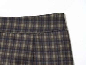 Detailopname van grijze geruite minirok met versterkte taille-stiksels en geweven textuur