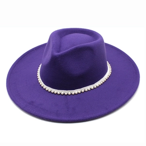 Detail of purple wool felt jazz hat featuring white pearl embellishments on the crown