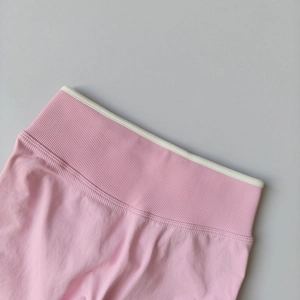 Close-up of pink high-waisted seamless yoga pants with rib-knit texture and white trim