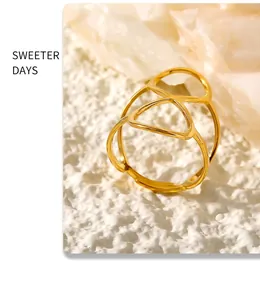 Macro detail of gold PVD plated adjustable figure-eight open ring on white background