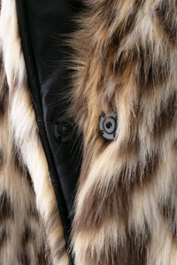 Détail de la fourrure synthétique brune et doublure en cuir noir avec boutons-pression mats