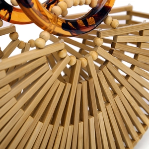 Detailed close-up of handmade bamboo bag with amber resin handle and wooden bead accents
