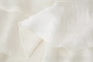 Close-up of lightweight white chiffon fabric with soft layered ruffles and textured finish