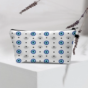 Waterproof white toiletry bag featuring blue evil eye pattern on a geometric display stand