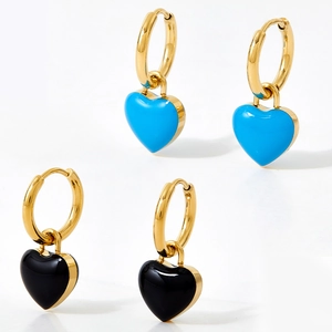 Detailed view of heart pendants in blue and black enamel with gold hoop earrings