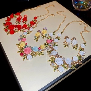 Detail of rose floral jewelry sets with pearls and rhinestones in three vibrant colors