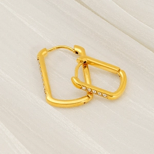 U-shaped gold stainless steel earrings with sparkling zircon stones on white fabric
