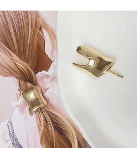 Close-up of elegant gold irregular geometric metal hair clip on low ponytail and display