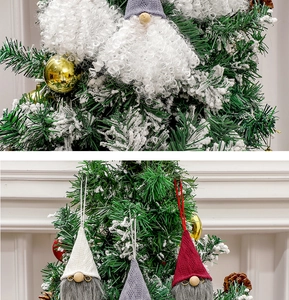 Detail of Christmas gnomes ornaments with long beards and knitted hats on tree branches