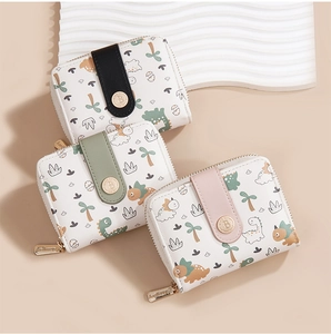 Three compact Baellerry wallets with cartoon dinosaur prints in black, green, and pink colors