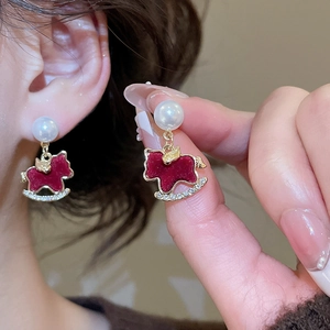 Detail of red flocked rocking horse earring with pearl stud and sparkling rhinestones