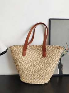 Large beige woven straw tote bag with brown leather handles for summer beach vacations