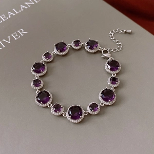 Detailed close-up of vintage gold plated bracelet with purple zircons and adjustable chain