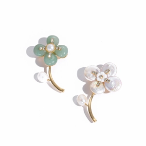 Detail of baroque pearl and green agate shell floral brooch with elegant gold stems