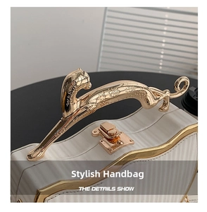 Detail of white box bag with a golden leopard handle and textured pleated surface