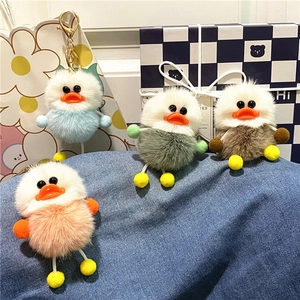 Set of four colorful plush duck keychains on denim with metal lobster clasps