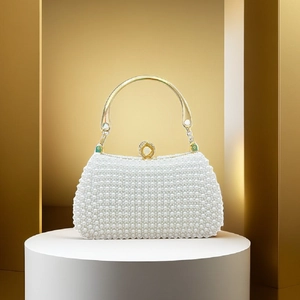 Close-up of luxury pearl evening bag with golden metal handle and ornate clasp
