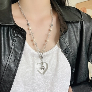Detail of gothic heart necklace featuring marble beads and vintage silver cross elements