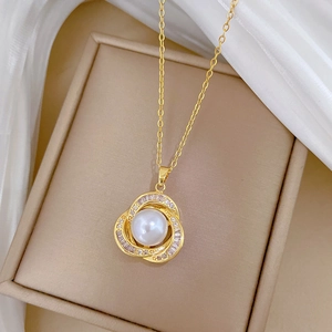 Detailed macro view of gold hollow nest pendant with white pearl and inlaid crystals