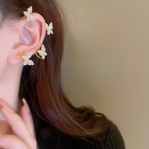 Detailed view of luxury gold butterfly ear cuffs with sparkling white cubic zirconia stones