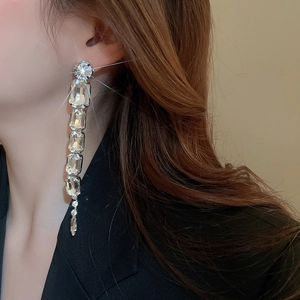 Close-up of long tassel earrings with sparkling transparent faceted crystal gems