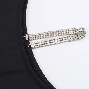 Détail de la robe noire en maille avec bretelles en strass à trois rangs et crochets