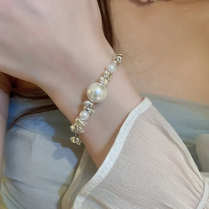 Elegant silver irregular bead and white pearl necklace worn on model wrist