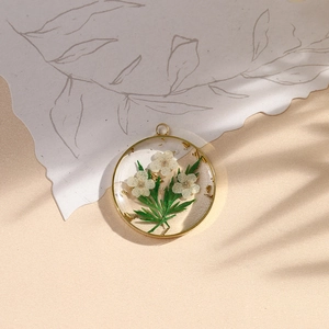 Handmade clear resin round pendant with real white flowers and gold leaf in gold frame