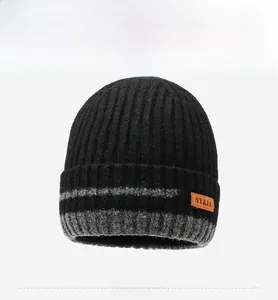 Detailed front view of black winter knit hat with grey stripes and leather logo patch
