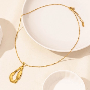 Macro detail of gold organic lava pendant with textured finish and lobster clasp