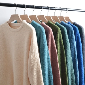 Close-up of knit sweaters in various colors showing detailed wool texture and crew neck design