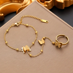 Close-up of golden stainless steel butterfly hand chain with bead links and adjustment detail