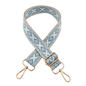 Close-up of blue and white geometric woven strap with adjustable gold metal hardware