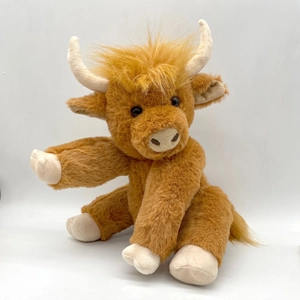 Detailed view of the long-haired brown plush highland cow with realistic beige horns