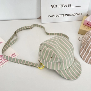 Detail of unique green and pink striped hat-shaped crossbody bag with adjustable strap