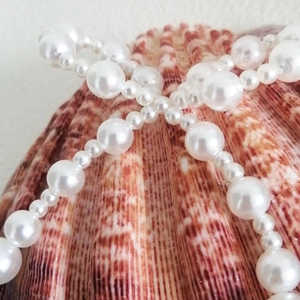 Macro shot of gradient white pearls on shell background for clothing accessories